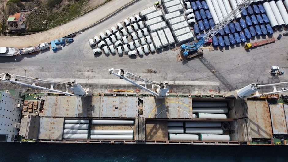 Aerial shot of a port in Lavrio, Greece, showcasing shipping and wind turbine components.